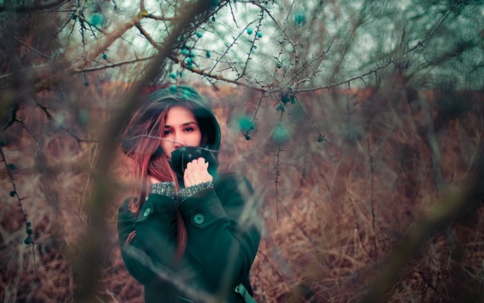 Woman in a hooded coat in a forest