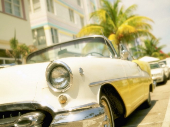 White and yellow vintage convertible car parked on street