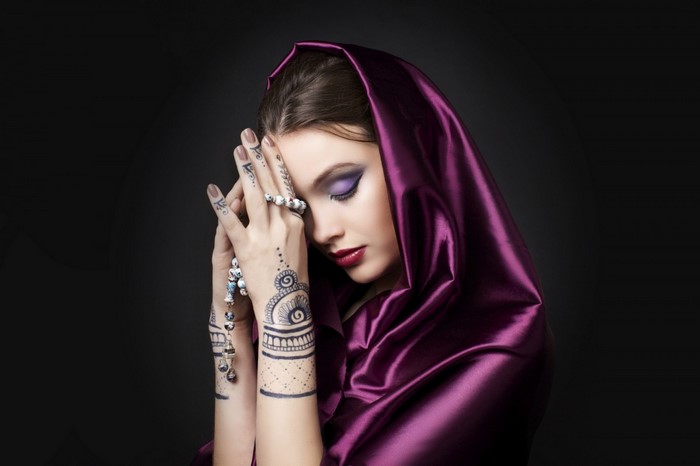 Woman with purple headscarf and henna tattoos