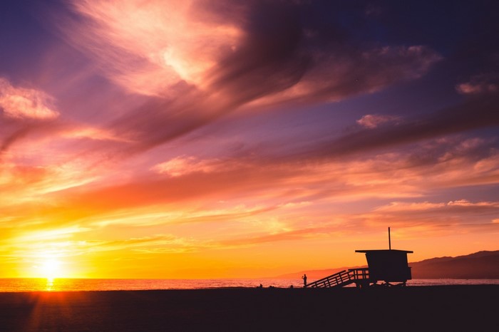 Sunset over the ocean with a lifeguard tower