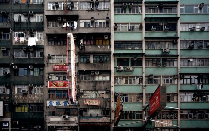Dense urban apartment buildings with many windows and air conditioners