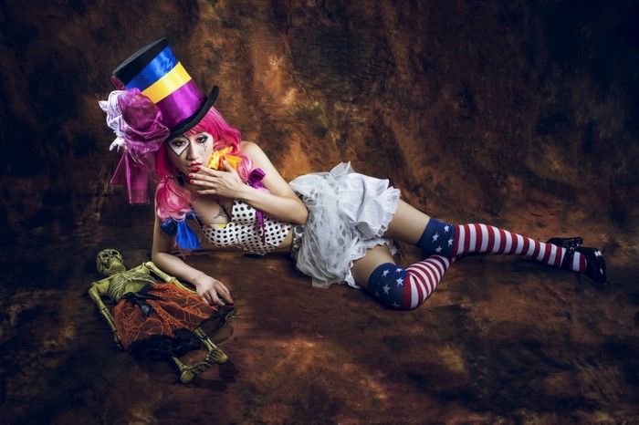 Woman in clown costume with skeleton prop