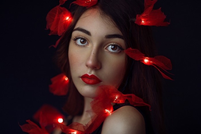Woman with red lights and petals