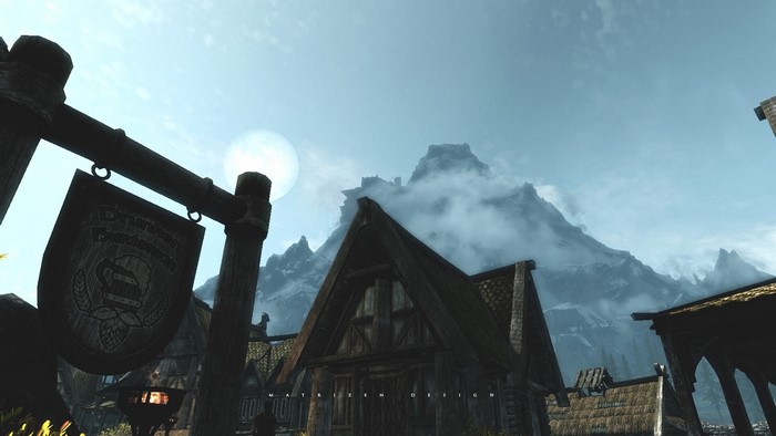The Elder Scrolls V Skyrim village with mountains
