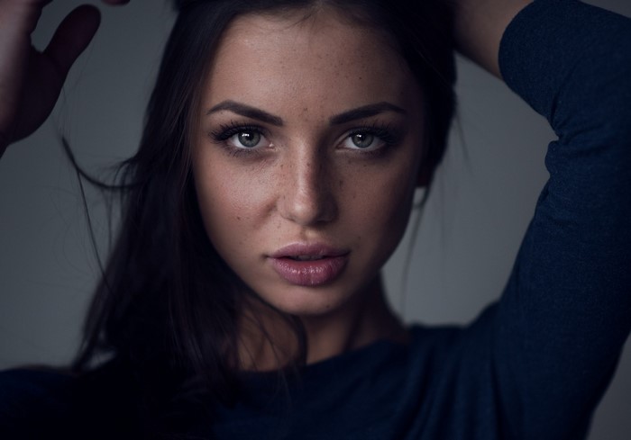 Woman with freckles and dark hair posing