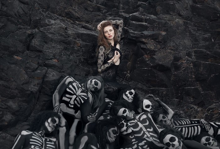 Women with skeleton body paint on rocky shore