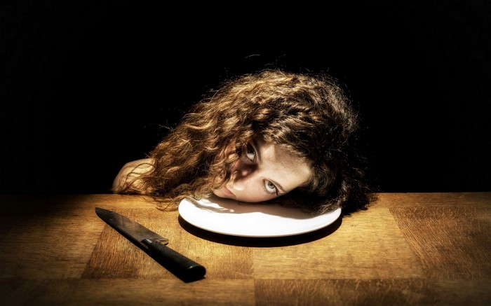 Woman's head on a plate with a knife