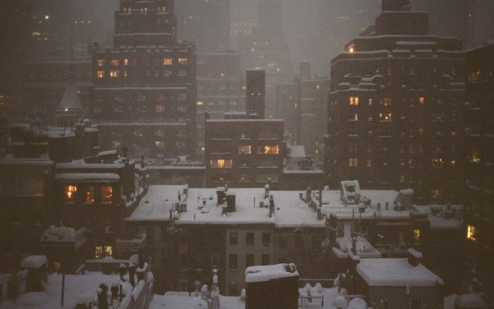 Cityscape at night with snow falling