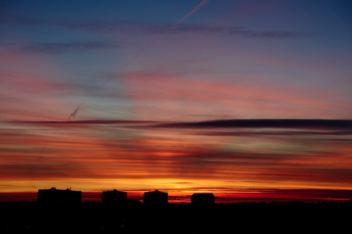 Silhouette of buildings against a colorful sunset sky