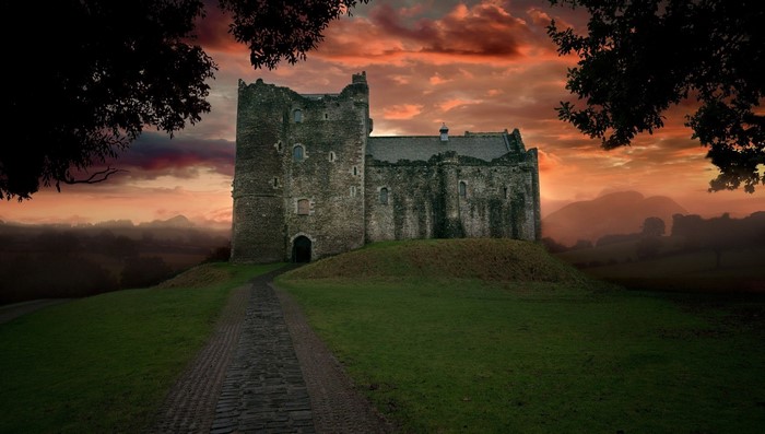 Castle on a hill at sunset with a path