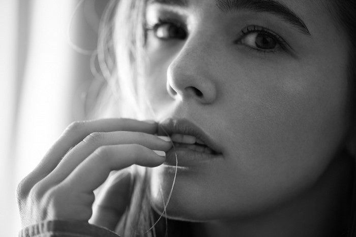 Monochrome portrait of a woman's face and hand