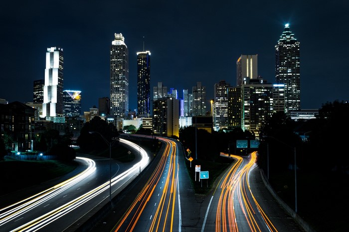 Cityscape at night with light trails on highways