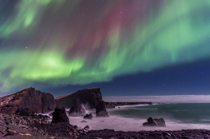 Aurora Borealis over rocky coast at night