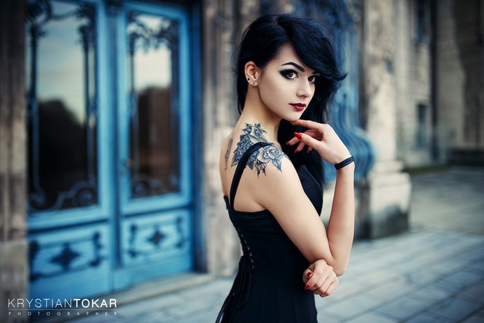 Woman with tattoo in front of blue doors