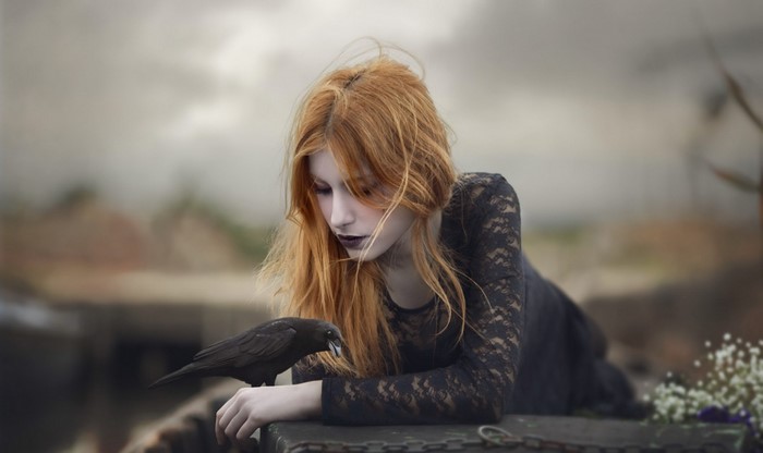 Woman with red hair and a raven
