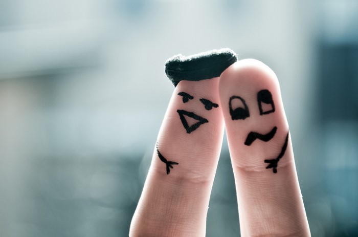 Finger puppets with drawn faces and a hat