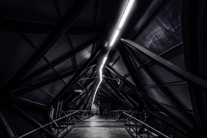 Monochrome architectural walkway with overhead lighting