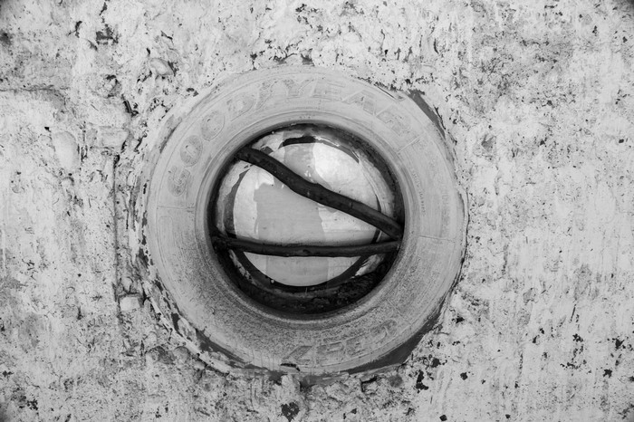 Goodyear tire embedded in a textured wall with rebar