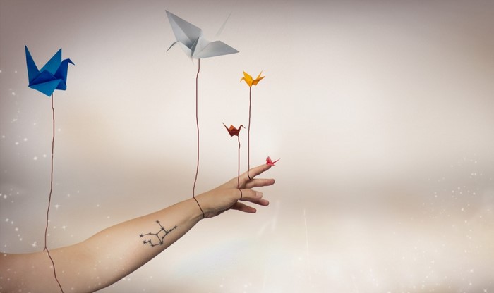 Origami cranes controlled by a tattooed arm