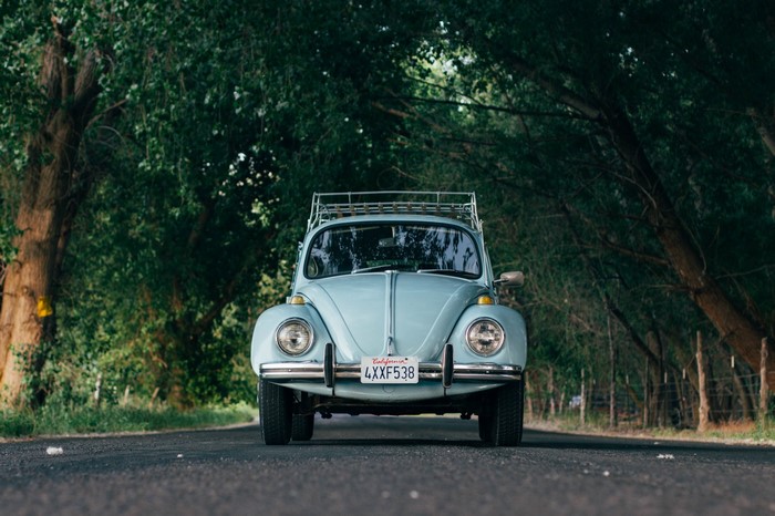 Light blue Volkswagen Beetle with roof rack on road