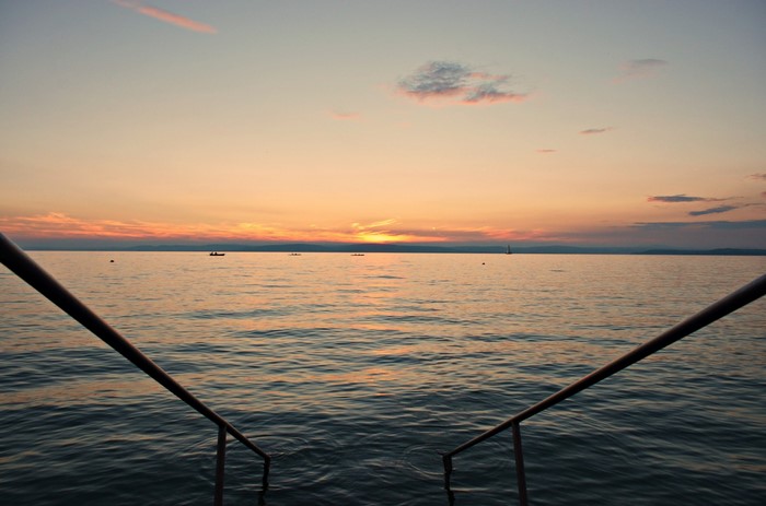 Sunset over Lake Balaton with boats and railings