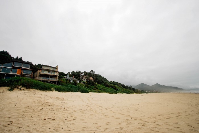 Houses on a hill overlooking a sandy beach and ocean