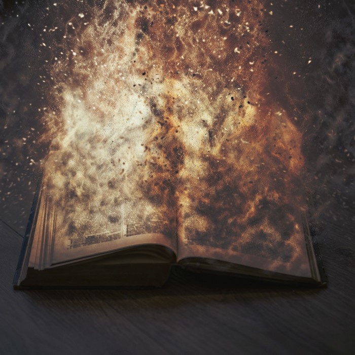 Open book exploding into cosmic dust and fire