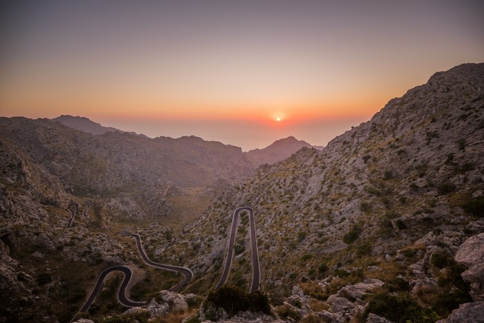 Winding mountain road at sunset