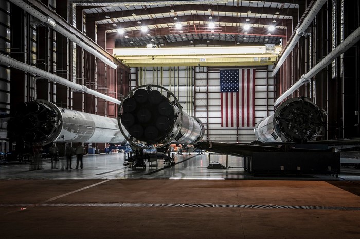 SpaceX Falcon 9 rockets in a hangar with American flag