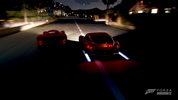 Two red sports cars racing at night in Forza Horizon 2