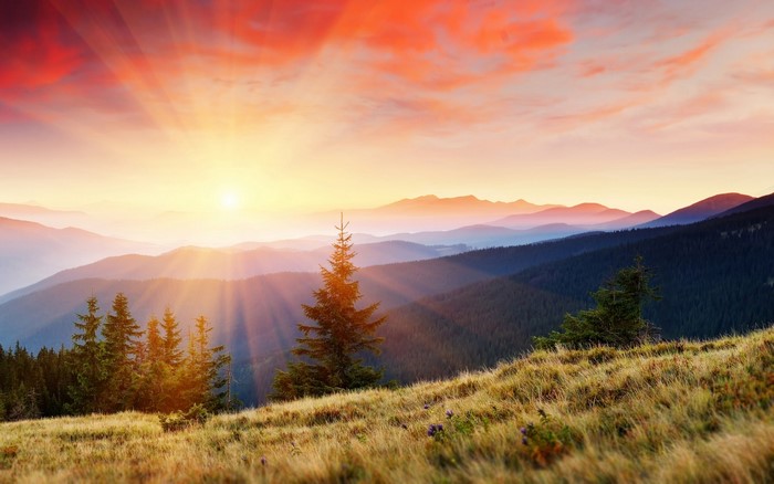 Sunrise over misty mountains with sun rays