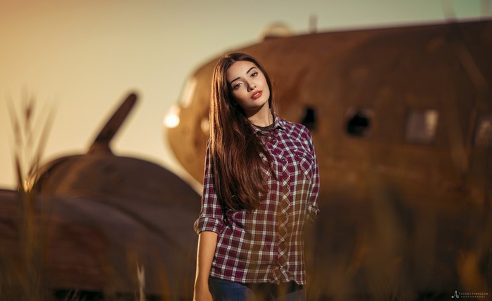 Woman in Plaid Shirt Poses Near Airplane Wreckage