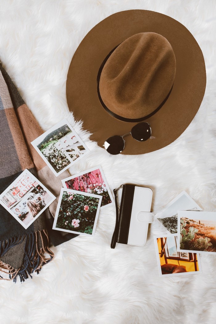 Flat lay of travel essentials on a white rug