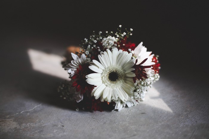 White and red gerbera flower bouquet on a concrete surface
