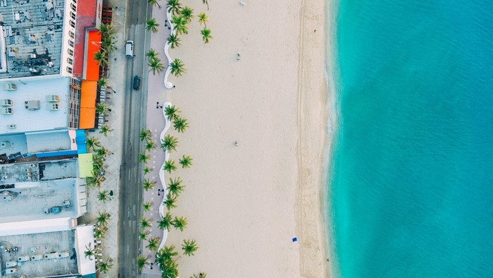 Aerial view of a beach with palm trees and turquoise water