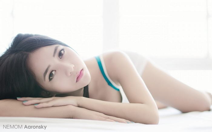 Asian woman with long black hair lying down
