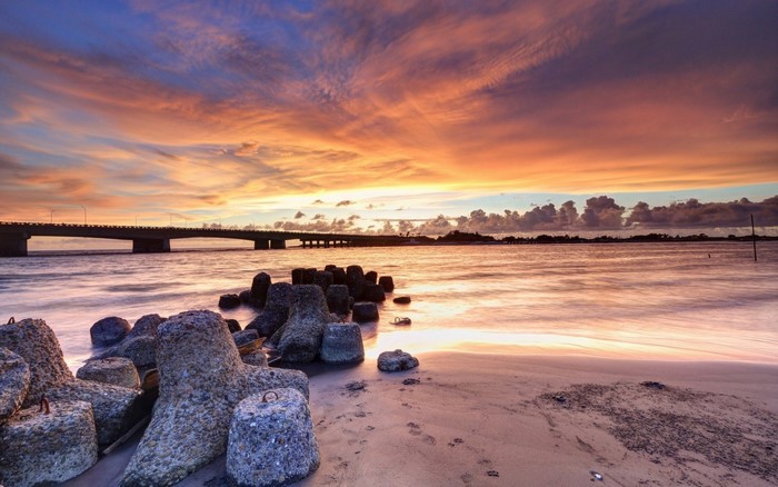 Sunset over the sea with a bridge and tetrapods