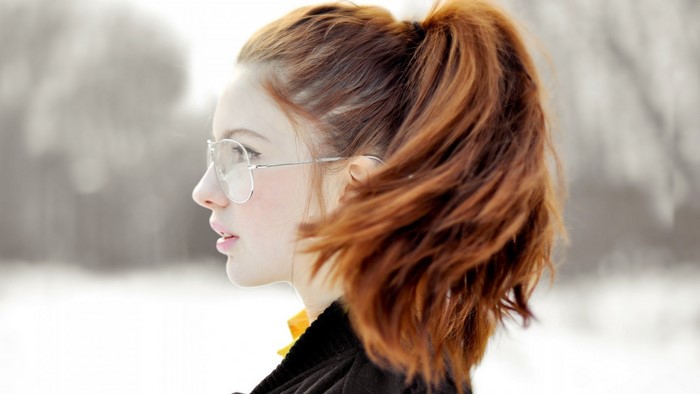 Woman with red hair and glasses in profile