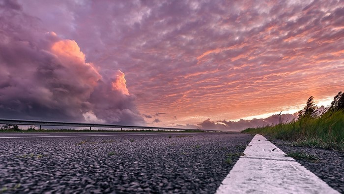 Road at sunset with dramatic clouds