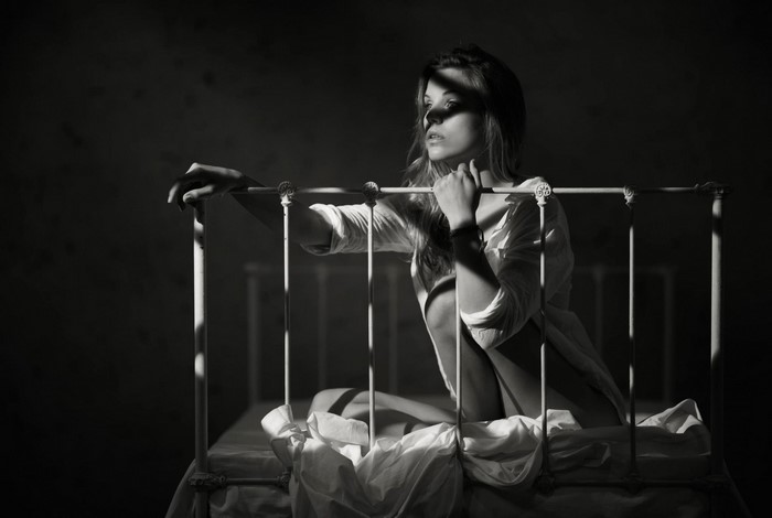 Monochrome portrait of a woman on a bed