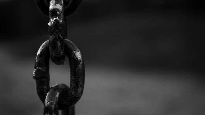 Close-up of a rusty metal chain in monochrome