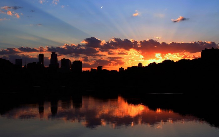 City skyline silhouette at sunset over water