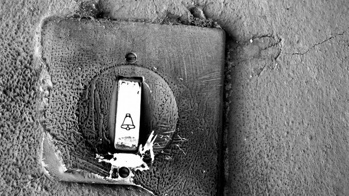 Close-up of an old doorbell with a bell symbol
