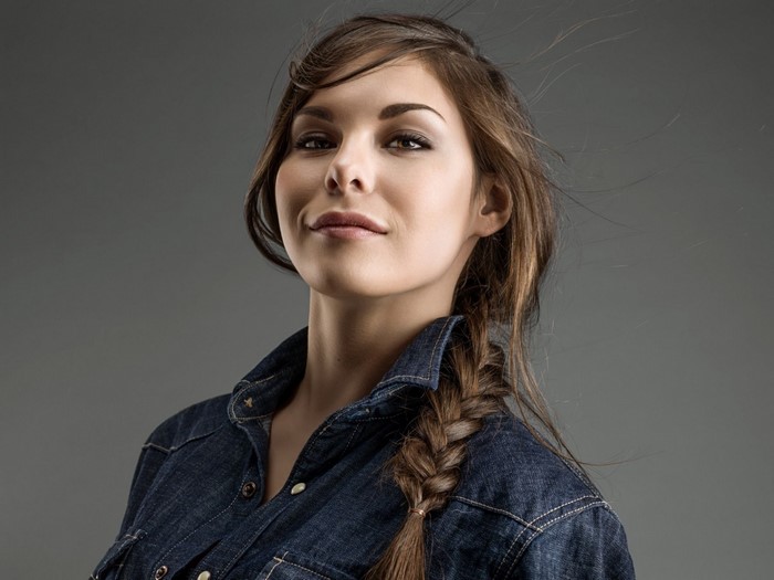Woman with braided brown hair wearing a denim shirt