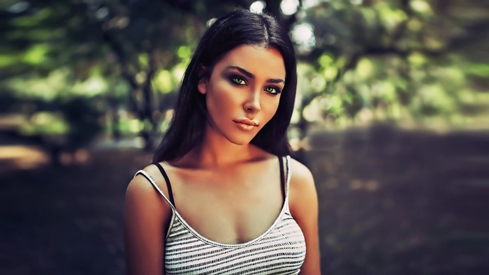 Woman with long black hair and green eyes in a striped top
