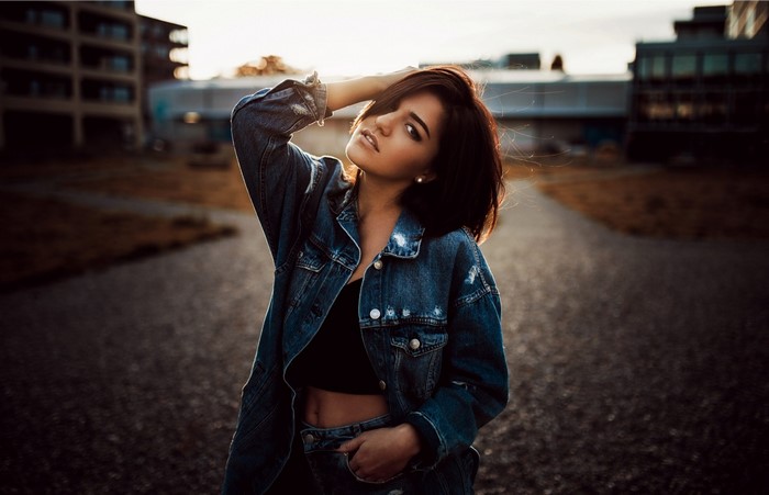 Woman in denim jacket posing outdoors