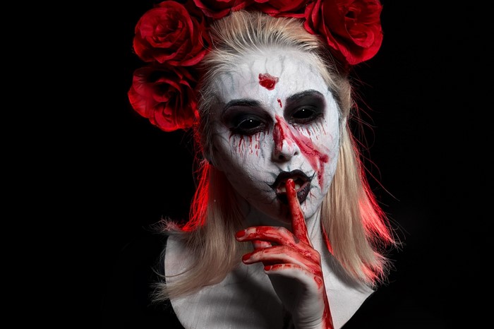 Woman with Halloween makeup and red roses