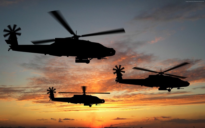 Three Boeing AH-64D Apache attack helicopters in flight