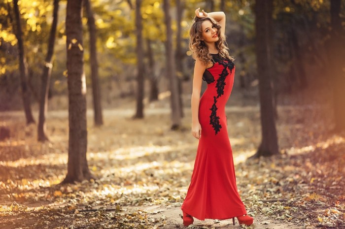 Woman in red dress in autumn forest