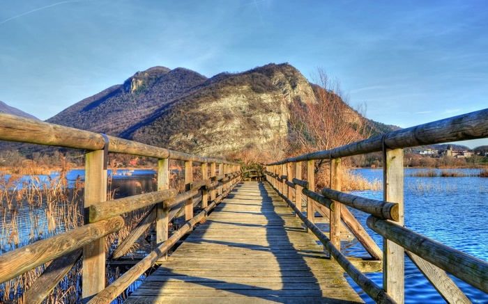 Wooden boardwalk over a lake with mountains in the background